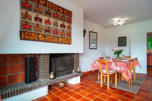 une salle à manger avec une table et une cheminée dans l'établissement Côté Mer - Maison familiale accès privé à la plage, à Sarzeau