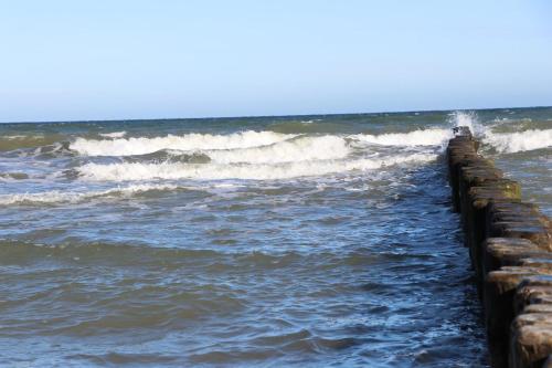 a person walking on a pier in the ocean at Fewo Meery in Bad Doberan