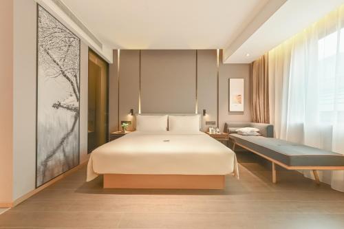 a bedroom with a large white bed and a couch at Atour Hotel Beijing Joy City Chaoyang Road in Beijing