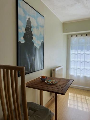 d'un salon avec une table et une peinture murale. dans l'établissement Escapade sur la Vilaine, à Guipry-Messac