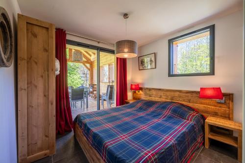 Un dormitorio con una cama y un balcón. en Chalet de l'alpette, en Valloire