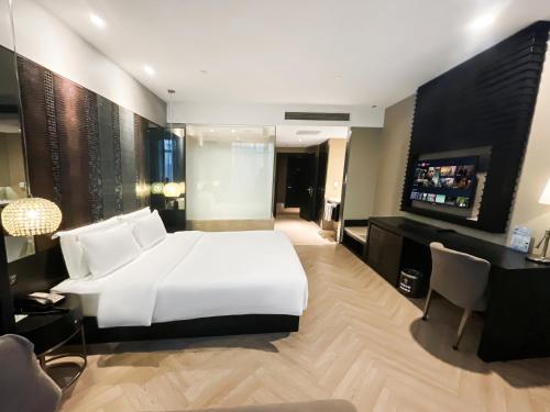a bedroom with a large white bed and a television at Crystal Orange Hotel Shanghai International Tourism Resort Chuansha in Shanghai
