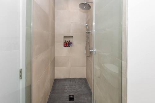 Un baño con ducha con puerta de cristal. en Modern 2BR Back House w/ TVs & Full Kitchen, en Los Ángeles
