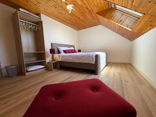 a bedroom with a bed and a red ottoman at Villa Luna in Oudsbergen 