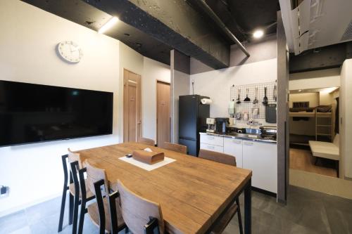 a kitchen and dining room with a wooden table and chairs at Stay Chill Shinbashi in Tokyo