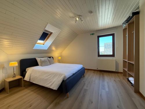 a bedroom with a large bed in a attic at Villa Luna in Oudsbergen 