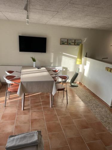 a dining room with a table and chairs and a tv at Lucky 3 Apartments in Løkken