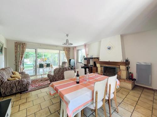 un salon avec une table et une cheminée dans l'établissement Charmante maison avec jardin, à Bussac-Forêt