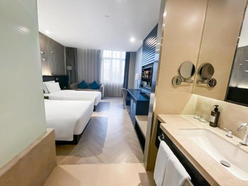 a hotel room with a bed and a sink at Crystal Orange Hotel Shanghai International Tourism Resort Chuansha in Shanghai