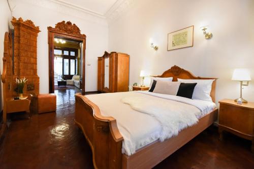 a bedroom with a large bed with white sheets at Timeless Elegance Meets Modern Comfort - Stay in the Heart of the Old Town in Bucharest
