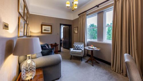 a living room with a couch and a chair and a window at Marcliffe in Aberdeen