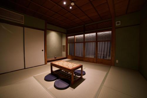 a room with a table in the middle of it at 長浜城下 町屋ホテル 和乃リトリートひといき in Nagahama
