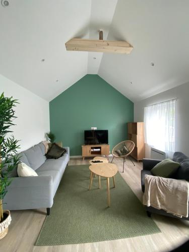 un salon avec un canapé et une table dans l'établissement Maison cosy à Aure sur Mer, à Sainte-Honorine-des-Pertes