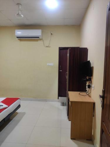 a room with a bed and a desk and a room with a heater at Hotel O Chez Pondy in Kottakupam