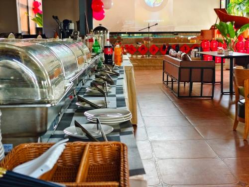 a restaurant with a long table with plates and utensils at Phoenix Dragon M.I.C.E Hotel in Kunming