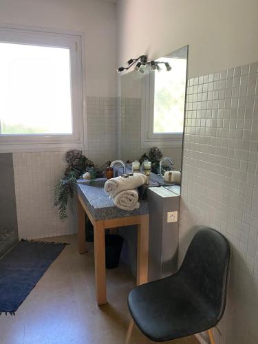 La salle de bains est pourvue d'un lavabo et d'une table avec une chaise. dans l'établissement Appartement with terrace, à La Ciotat