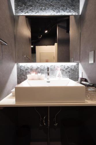 a bathroom with a white sink and a mirror at Stay Chill Shinbashi in Tokyo