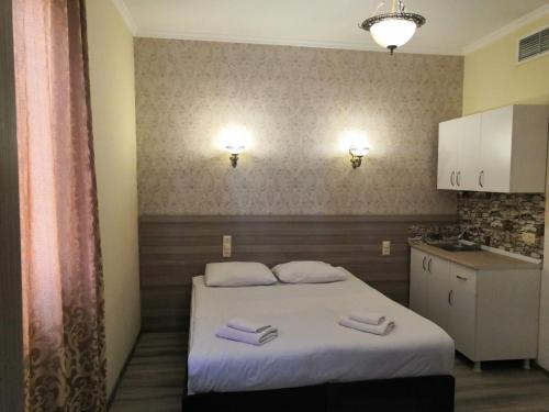 a bedroom with a bed with two towels on it at MyRose Grand Hotel, Batumi in Batumi
