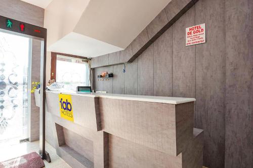 a lobby with a counter with a sign on the wall at FabExpress De Gold Karol Bagh in New Delhi