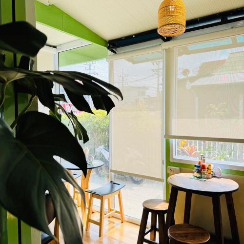 a room with chairs and a table and a plant at Southwayhome in Koh Phangan