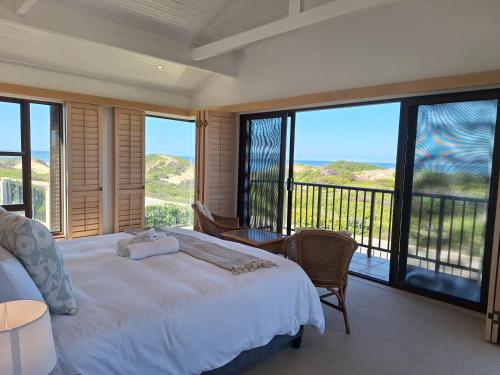 une chambre avec un lit et une vue sur l'océan dans l'établissement Ocean Mooring Beach Apartments, à Port Alfred