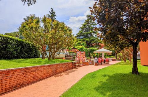 a brick wall with a table and chairs in a park at Casa Carla in Peschiera del Garda