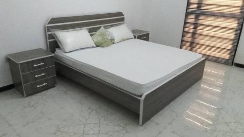 a bedroom with a large bed with two night stands at Sali- Laye Diass in Darou Rhamane