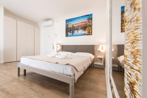 a bedroom with a bed and a painting on the wall at Guesthouse Stadio in Lignano Sabbiadoro