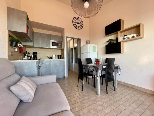 un salon et une cuisine avec un canapé et une table dans l'établissement Appartement 2 pièces avec parking et climatisation à Sète - FR-1-338-419, à Sète