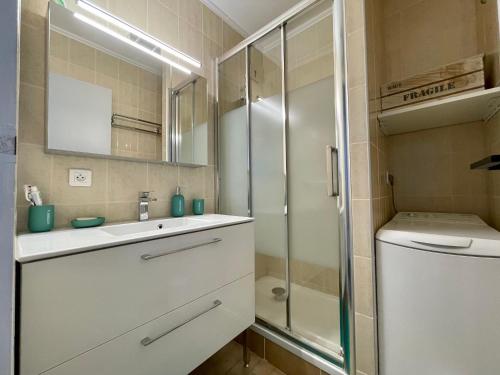 une salle de bain avec un lavabo et une douche en verre dans l'établissement Appartement 2 pièces avec parking et climatisation à Sète - FR-1-338-419, à Sète