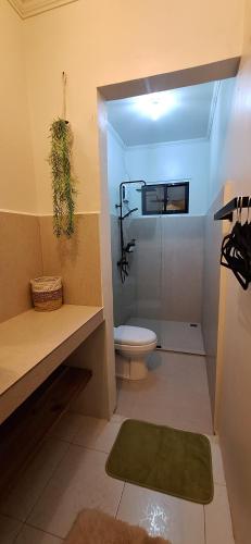 a bathroom with a toilet and a glass shower at Little house in El Nido