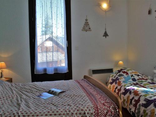 - une chambre avec un lit et une fenêtre avec un livre dans l'établissement Appartement cosy à Risoul 1850 : 2 pièces, coin montagne, 6 couchages, ski aux pieds, terrasse sud - FR-1-330-125, à Risoul