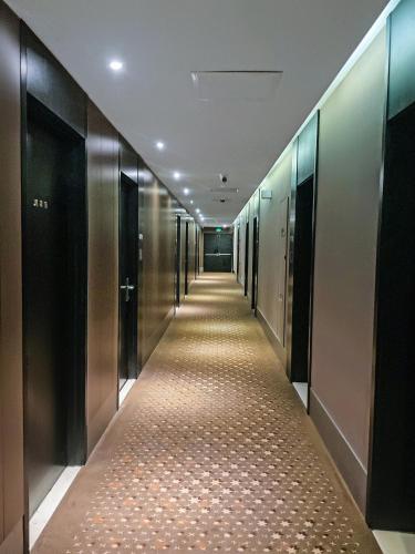 a corridor of elevators in a building with a long hallway at Crystal Orange Hotel Shanghai International Tourism Resort Chuansha in Shanghai