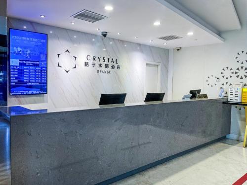 a lobby with a counter with two laptops on it at Crystal Orange Hotel Shanghai International Tourism Resort Chuansha in Shanghai