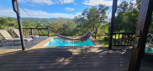 a hammock on a deck next to a pool at Robin Cottage Da Gama Lake in White River