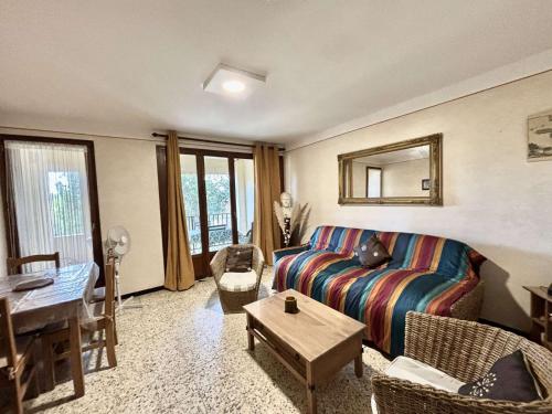 ein Wohnzimmer mit Sofa und Tisch in der Unterkunft Studio Résidence de La Mer L'ILE-ROUSSE in LʼÎle-Rousse