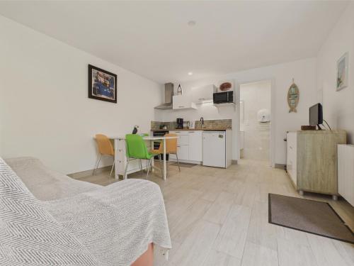 un salon avec une cuisine et une salle à manger dans l'établissement Maisonnette 4 personnes - 300m de la plage, à Penvénan