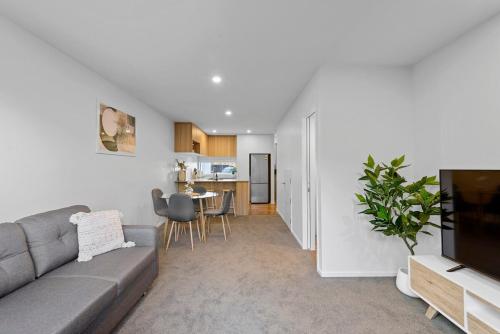 a living room with a couch and a tv at Cosy Oasis Close To CBD in Christchurch