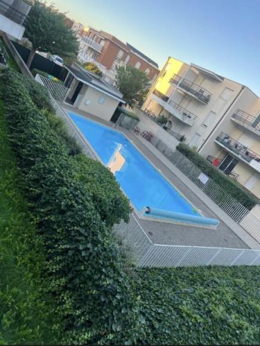 une grande piscine bleue à côté d'une haie dans l'établissement T3- 2 Chambres ZENITH STRASBOURG TRAMWAY, à Strasbourg