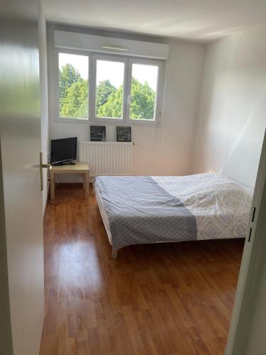 une chambre avec un lit et un bureau et deux fenêtres dans l'établissement T3- 2 Chambres ZENITH STRASBOURG TRAMWAY, à Strasbourg