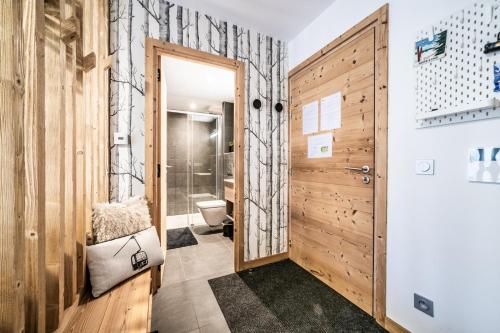 une salle de bain avec toilettes et porte en bois dans l'établissement Echo du Pleney B004, à Morzine