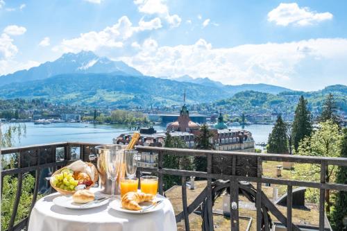 a table with food and drinks on a balcony with a view at Hotel Royal Luzern in Luzern