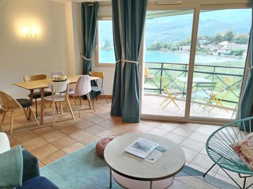 - un salon avec vue sur l'eau dans l'établissement Superbe Duplex les pieds dans l'eau Vue Lac et Château avec Plage et parking Privés, à Duingt