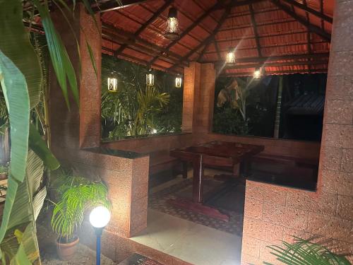 a wooden table in a room with some plants at Fraydel Homestay in Honāvar