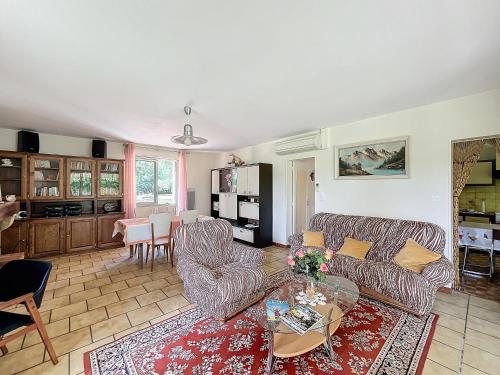 un salon avec un canapé et une table dans l'établissement Charmante maison avec jardin, à Bussac-Forêt