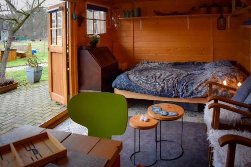 a bedroom with a bed and a green chair at Bed and Breakfast 'Op de Kleijne Hei' in Well