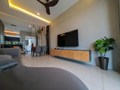 a living room with a flat screen tv on a wall at Sunny Bear Suites, Alor Setar in Alor Setar