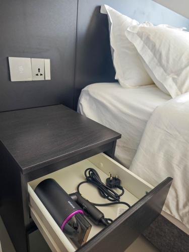 a box with a desk and a phone on a bed at Sunny Bear Suites, Alor Setar in Alor Setar