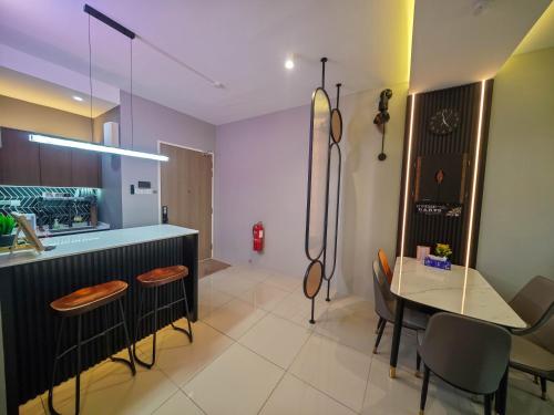 a kitchen with a counter and a table with chairs at Sunny Bear Suites, Alor Setar in Alor Setar