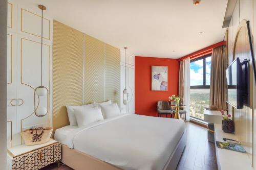 a bedroom with a white bed and a red wall at Apec Mandala Mũi Né Resorts & Hotels NN in Phan Thiet